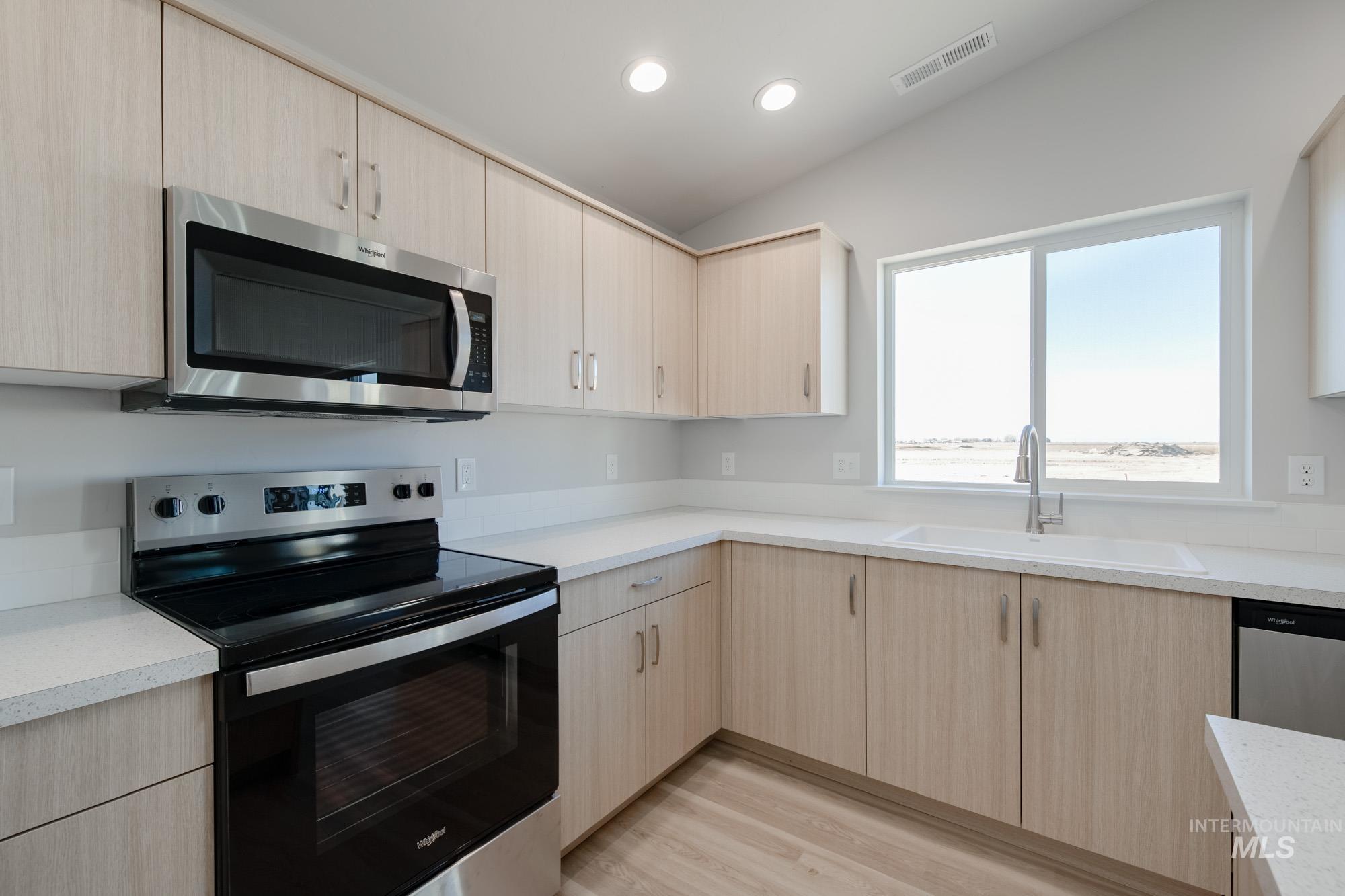 7472 South Menzingers Avenue Meridian, ID 83642 - Photo 6 of 22 Kitchen featuring light brown cabinets, stainless steel appliances, light wood finished floors, recessed lighting, and modern cabinets