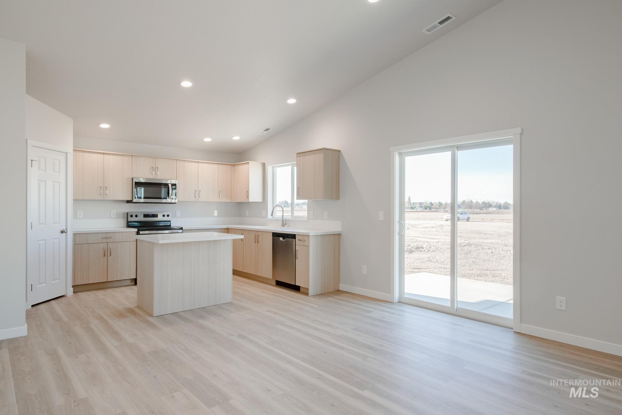 7472 South Menzingers Avenue Meridian, ID 83642 - Photo 9 of 22 Kitchen featuring a kitchen island, light countertops, light wood finished floors, light brown cabinetry, and recessed lighting