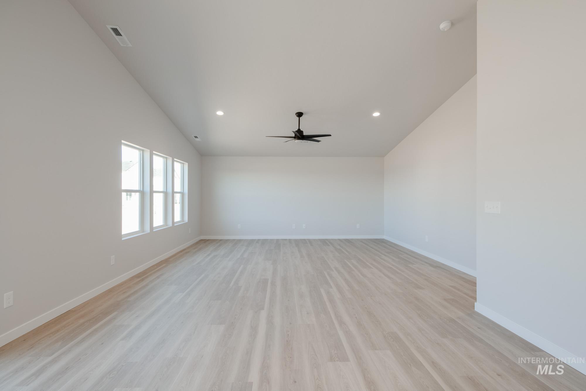 7472 South Menzingers Avenue Meridian, ID 83642 - Photo 10 of 22 Spare room featuring vaulted ceiling, light wood-type flooring, recessed lighting, and a ceiling fan