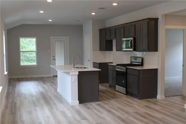 a kitchen with a sink and a stove top oven