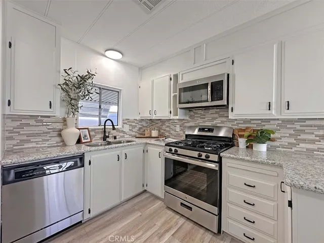 a kitchen with granite countertop a stove sink and cabinets