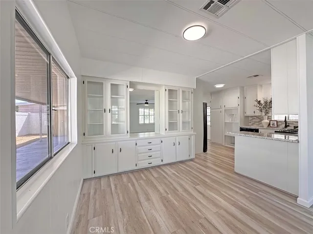 a large white kitchen with kitchen island a sink a stove and white cabinets
