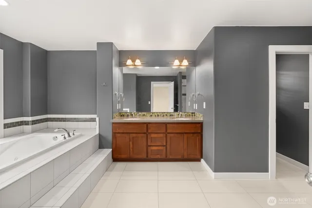 a spacious bathroom with a tub sink and mirror