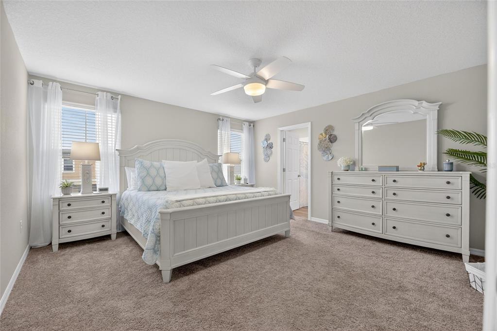 12908 Hawkstone Trail Boulevard Lithia, FL 33547 - Photo 22 of 76 a spacious bedroom with a bed and a chandelier