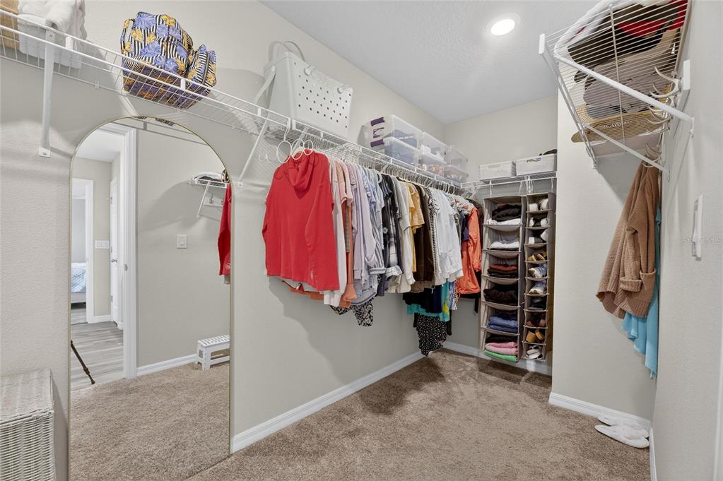 12908 Hawkstone Trail Boulevard Lithia, FL 33547 - Photo 28 of 76 a view of walk in closet with clothes and shoes