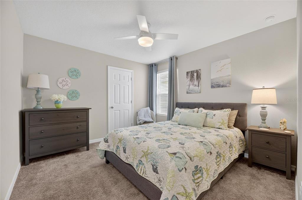 12908 Hawkstone Trail Boulevard Lithia, FL 33547 - Photo 30 of 76 a bedroom with a bed and a lamp on dresser