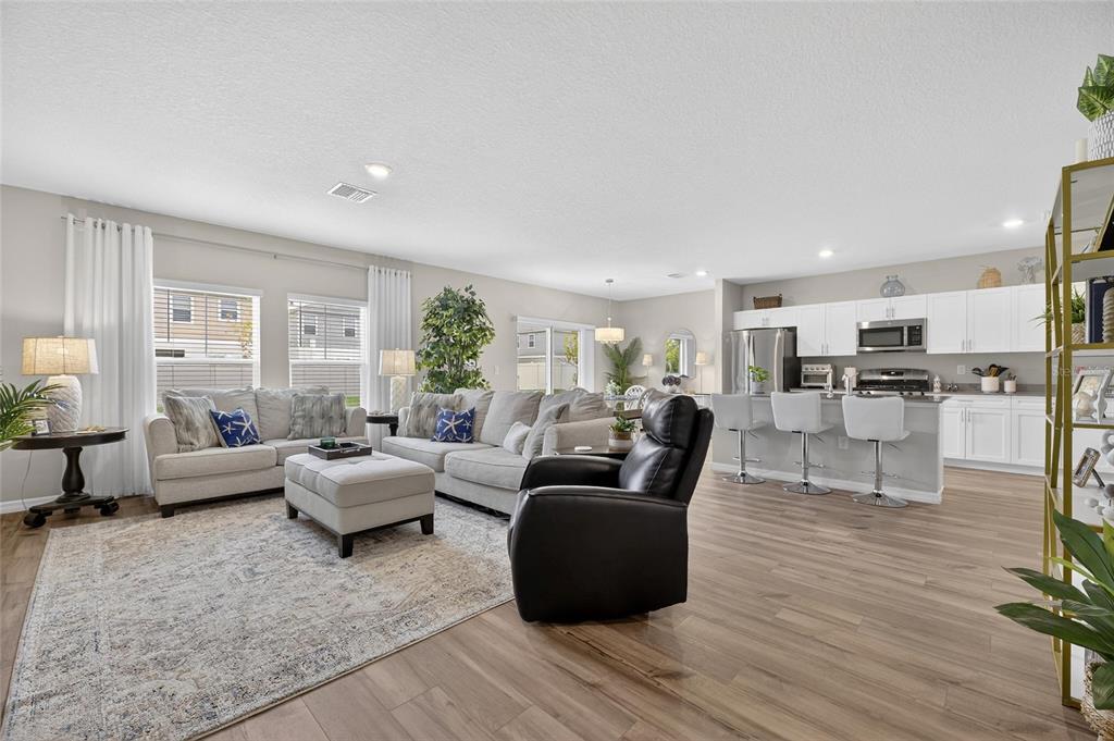 12908 Hawkstone Trail Boulevard Lithia, FL 33547 - Photo 3 of 76 a living room with furniture and view of kitchen