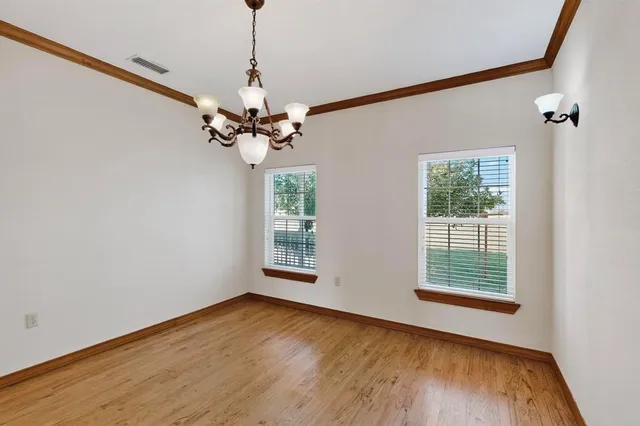 a view of a room with a large window a ceiling fan and wooden floor