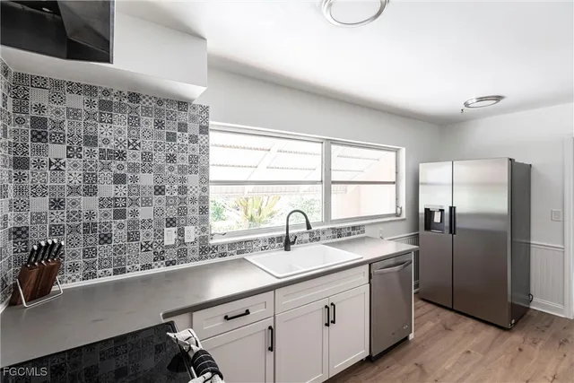 a kitchen with stainless steel appliances a sink and a window