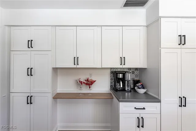 a kitchen with white cabinets and white appliances