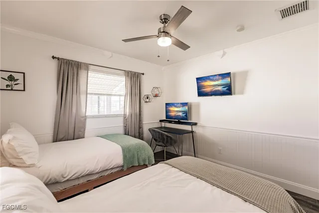 a bedroom with two beds and a flat screen tv