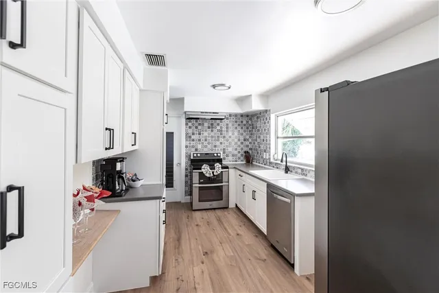 a kitchen with stainless steel appliances a sink and a refrigerator
