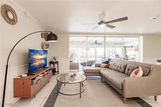 a living room with furniture a flat screen tv and a large window