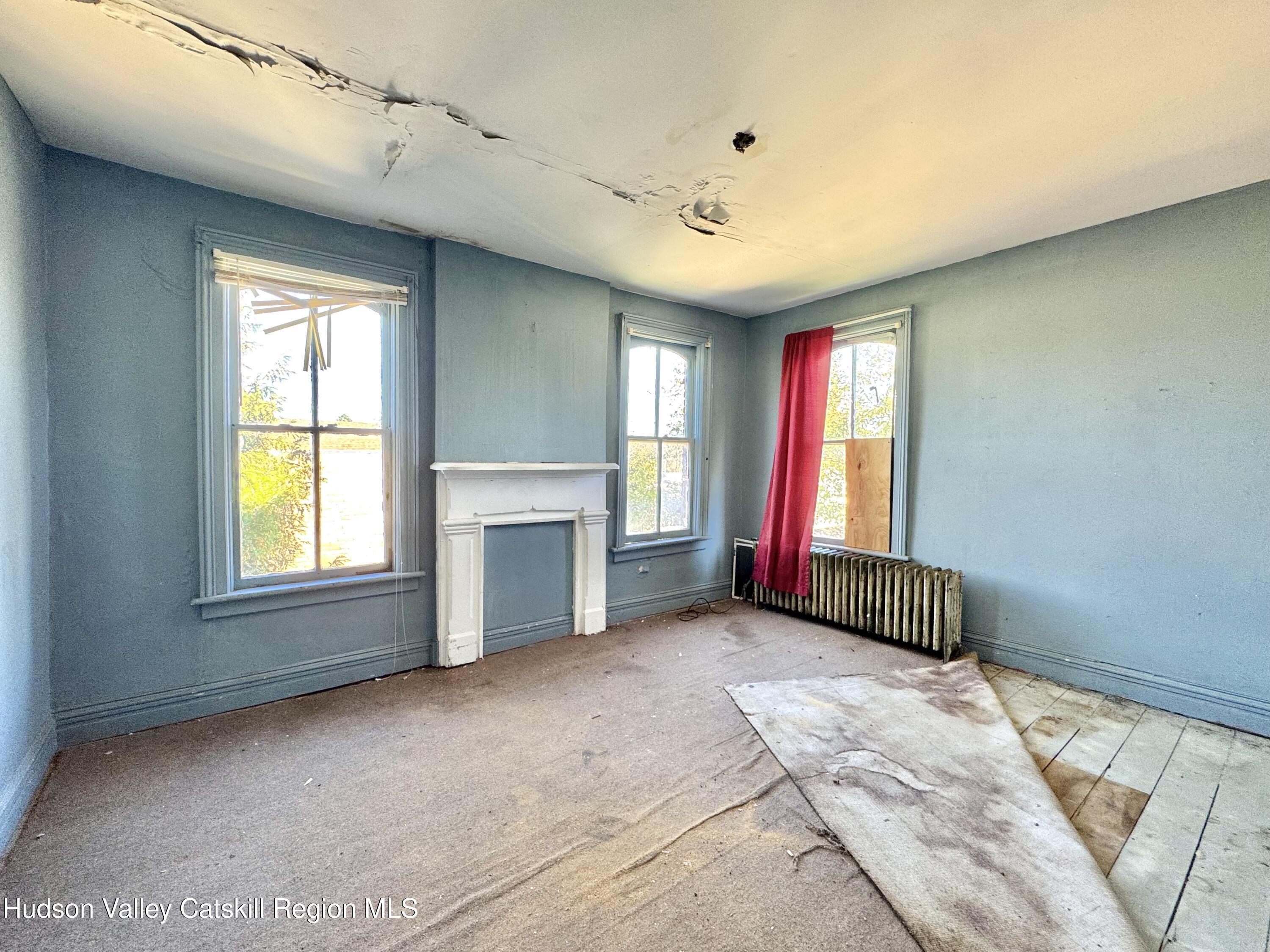 8 Howell Street Catskill, NY 12414 - Photo 7 of 14 a view of an empty room with window and a fireplace