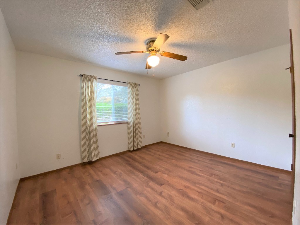 5502 Honey Dew Terrace Austin, TX 78749 - Photo 15 of 18 an empty room with wooden floor ceiling fan and windows