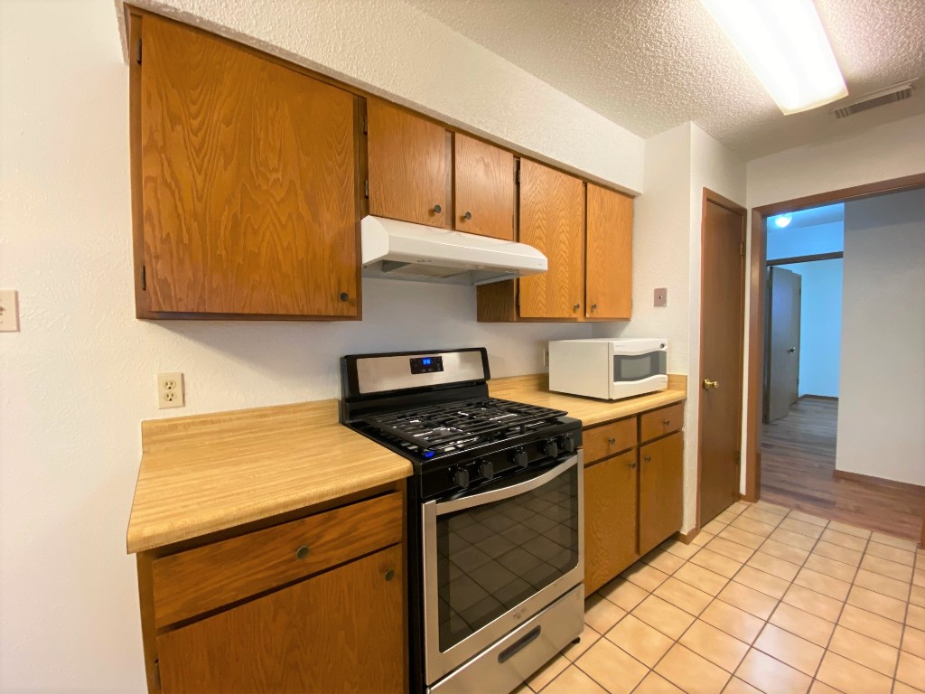5502 Honey Dew Terrace Austin, TX 78749 - Photo 7 of 18 a kitchen with a stove and a microwave