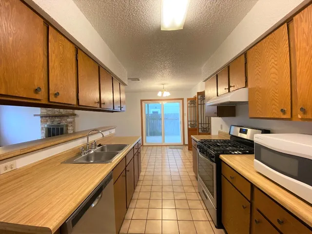 a kitchen with a sink a stove and cabinets