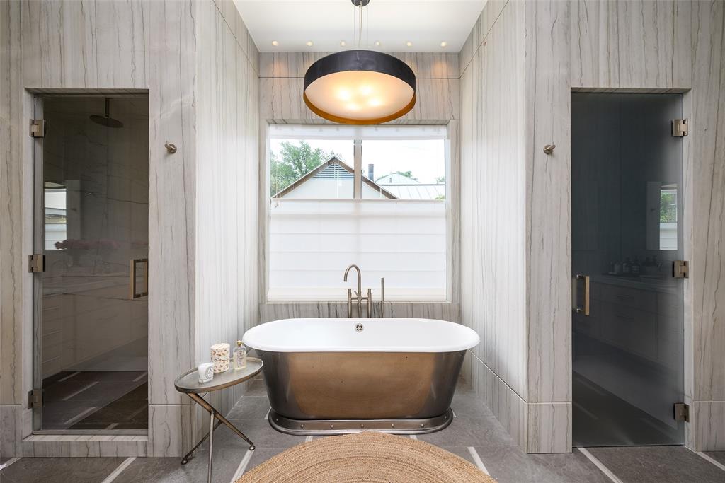 3511 Springbrook Street Dallas, TX 75205 - Photo 32 of 38 Freestanding metallic soaking tub with a floor-mounted faucet, flanked by two glass-enclosed shower spaces