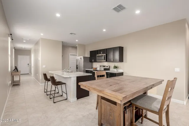 a kitchen with a table chairs microwave and cabinets