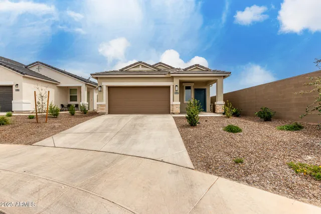 a view of a white house with large windows and palm trees