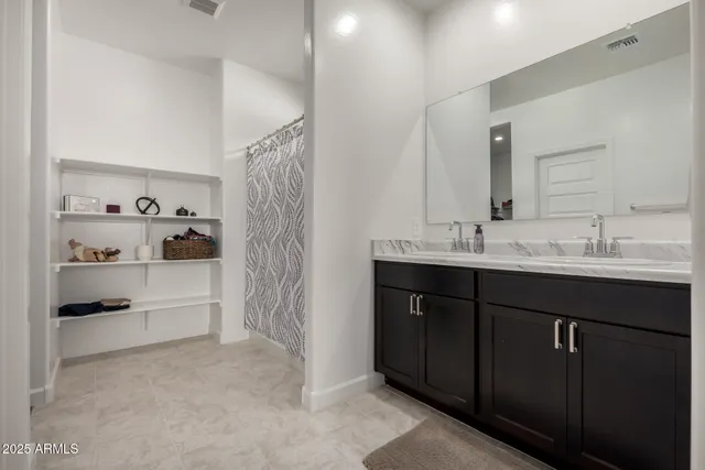 a bathroom with a double vanity sink a tub and shower