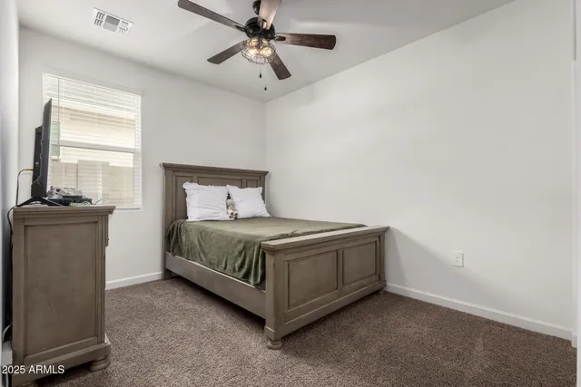 a spacious bedroom with a bed and a chandelier