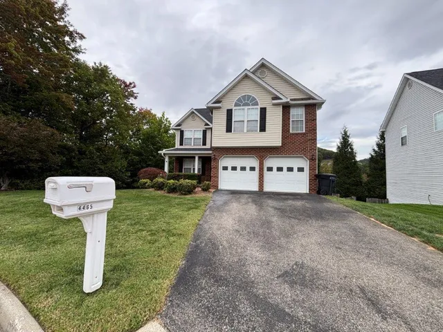 a front view of a house with a garden and trees