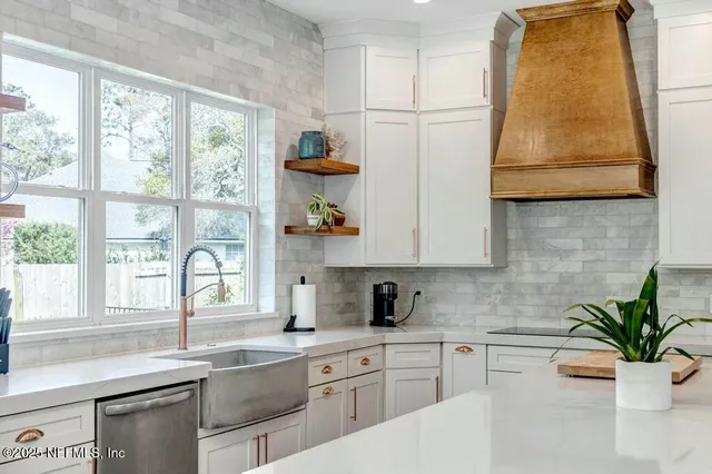a kitchen with a sink a window and cabinets
