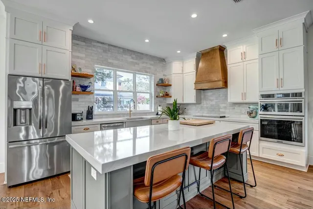 a kitchen with stainless steel appliances granite countertop a stove a sink a refrigerator and a refrigerator