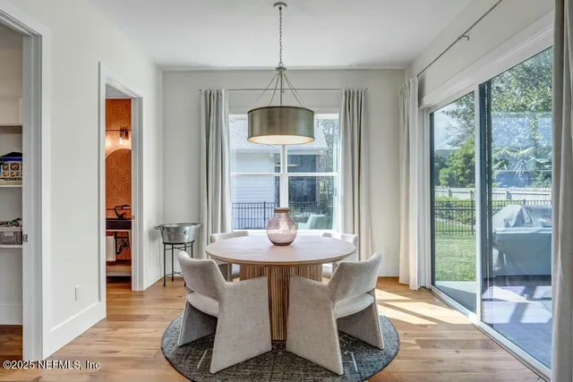 a dining room with furniture wooden floor and a chandelier