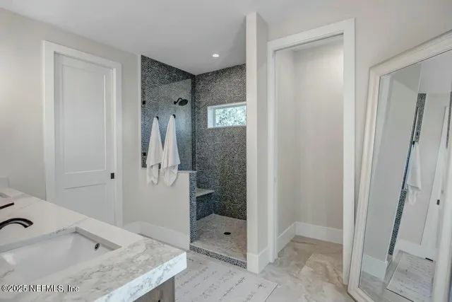 a bathroom with a granite countertop sink and shower