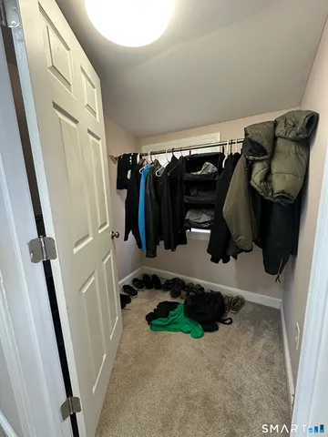a view of walk in closet with clothes and shoes