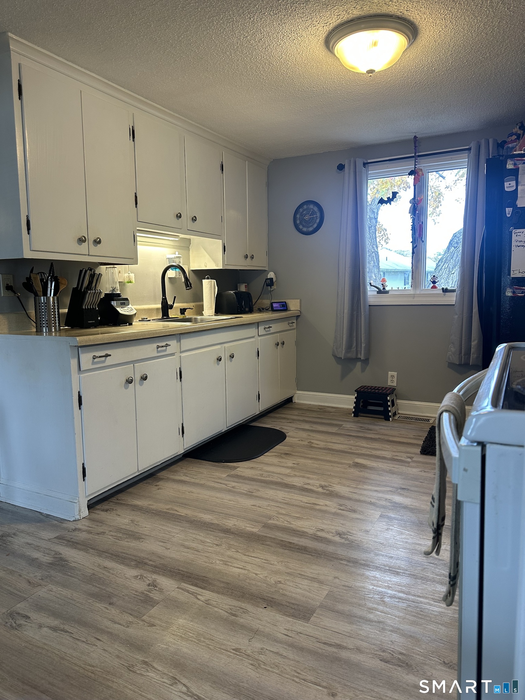 1031 Meriden Road Waterbury, CT 06705 - Photo 2 of 30 a kitchen with cabinets wooden floor and a sink