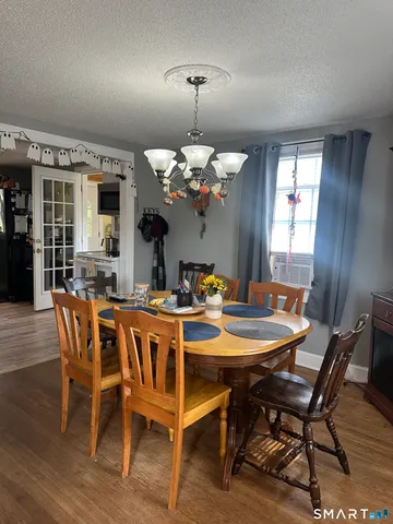 a dining room with furniture a chandelier and wooden floor