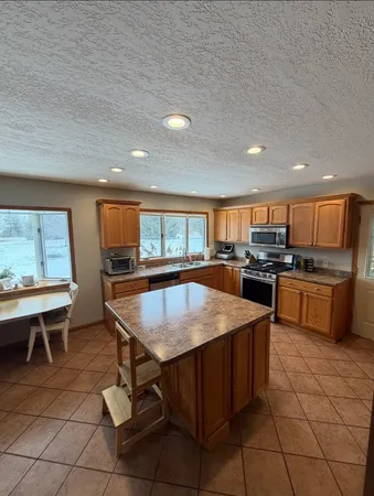 a kitchen with stainless steel appliances granite countertop a stove top oven a sink a counter space and cabinets