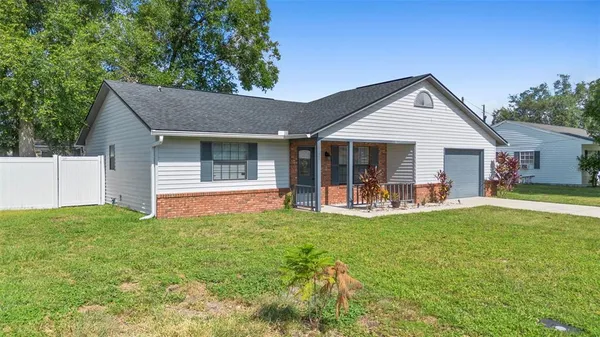 a view of a house with a yard and porch