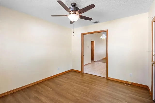a view of a livingroom with wooden floor and a ceiling fan