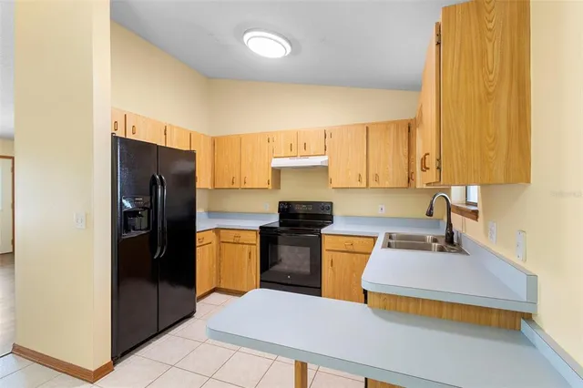 a kitchen with stainless steel appliances a sink cabinets and a window
