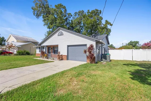 a view of a backyard with grass and a large tree