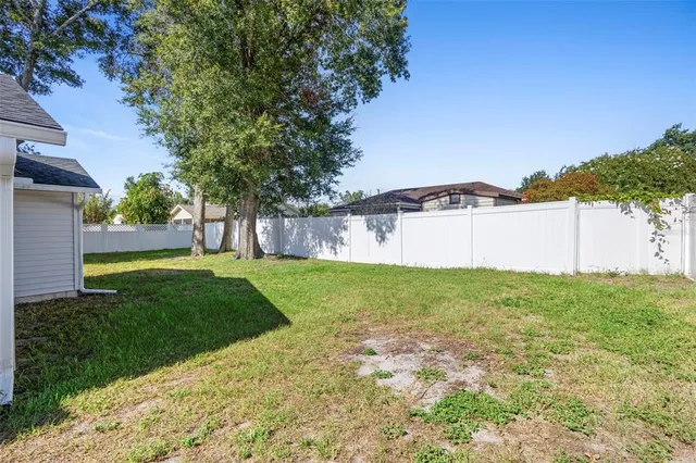 a view of a house with backyard and tree