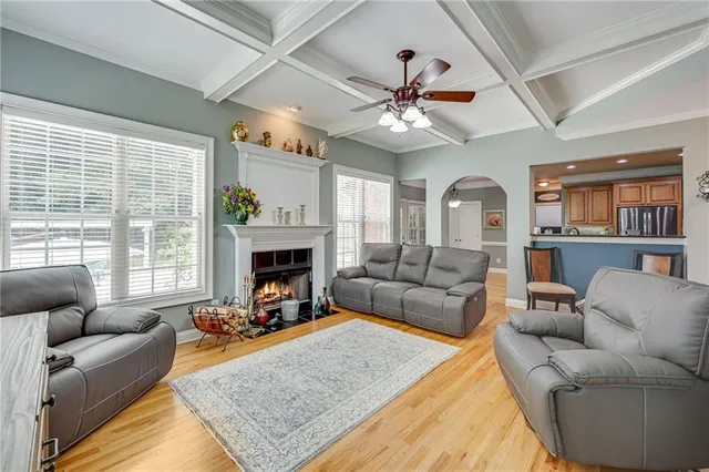 a living room with furniture a fireplace and a large window