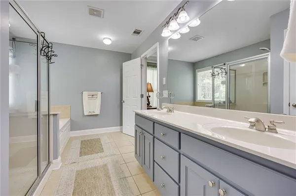 a spacious bathroom with a double vanity sink mirror and shower