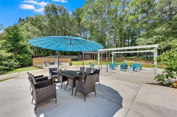a view of backyard with table and chairs under an umbrella