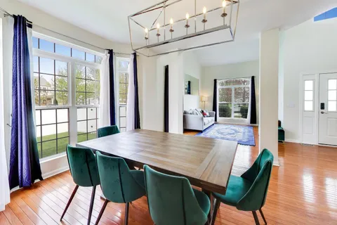a view of a dining room with furniture a chandelier and wooden floor
