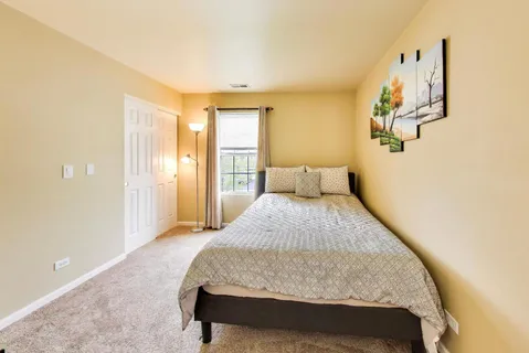 a bathroom with a white bed and a chandelier