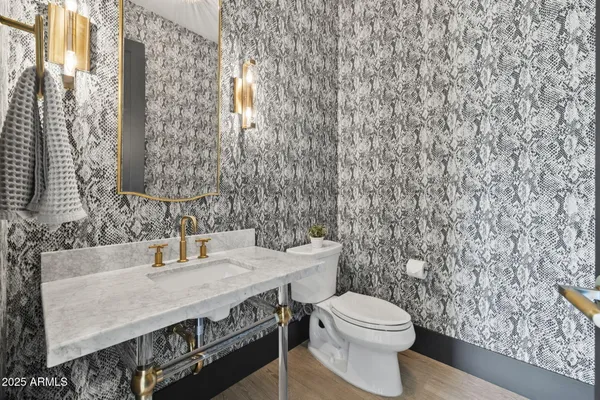 a bathroom with a granite countertop toilet sink and mirror