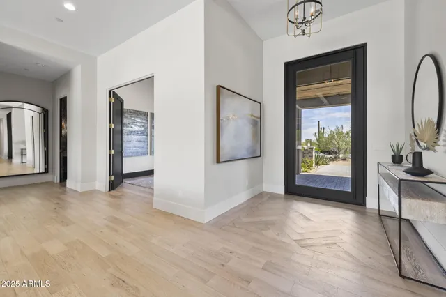 a large white kitchen with a large window a sink and wooden floor
