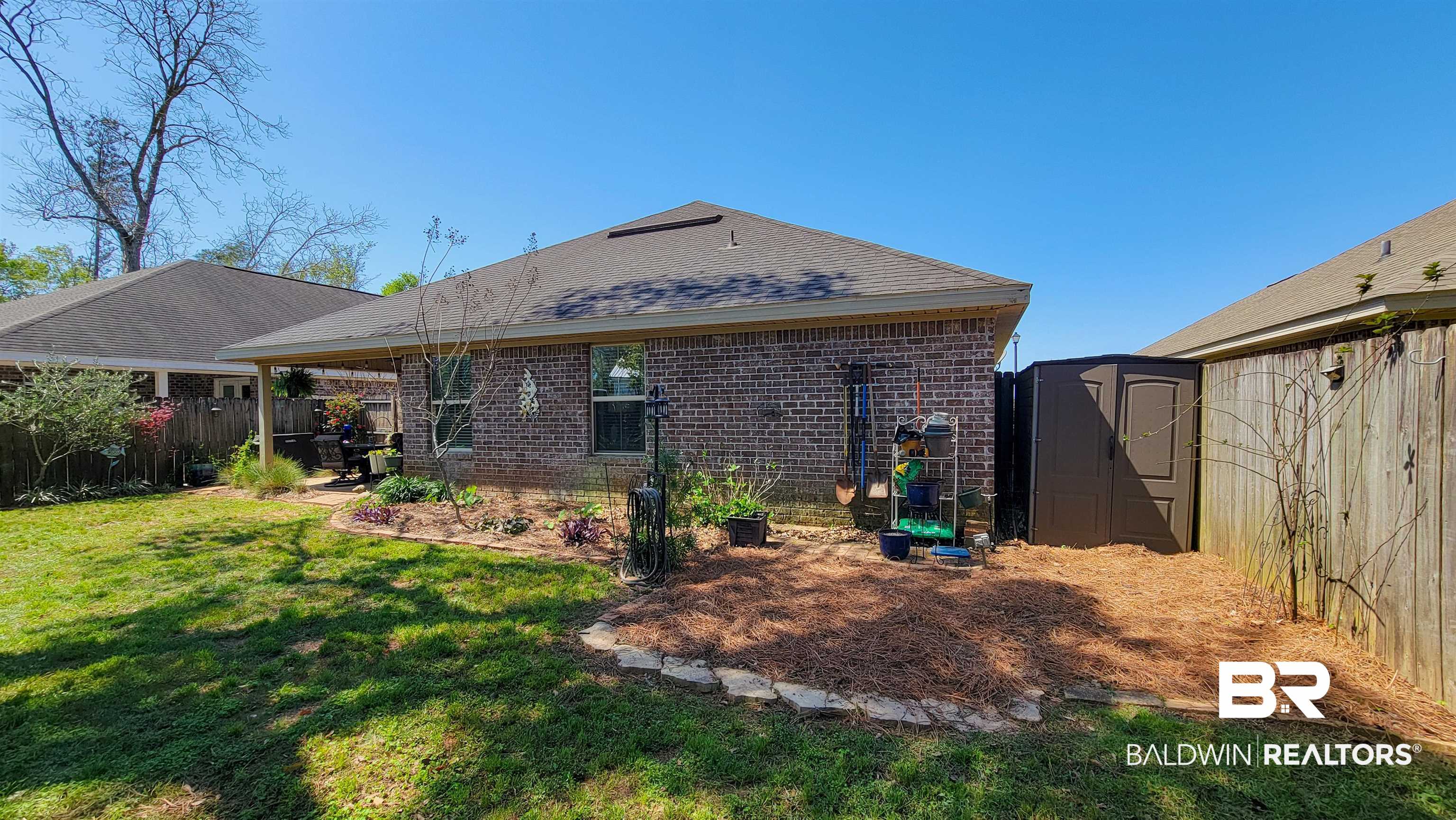 1304 Majesty Loop Foley, AL 36535 - Photo 30 of 44 Back of house featuring a storage shed, a fenced backyard, a patio, and brick siding