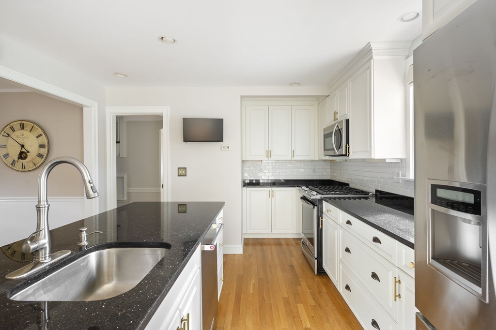 19 Lantern Lane Milton, MA 02186 - Photo 12 of 39 a kitchen with granite countertop a sink a stove and cabinets