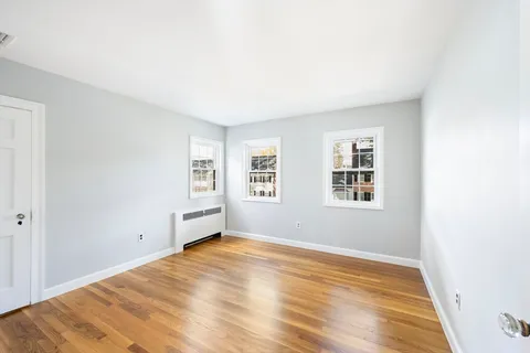 a view of a room with wooden floor and white walls